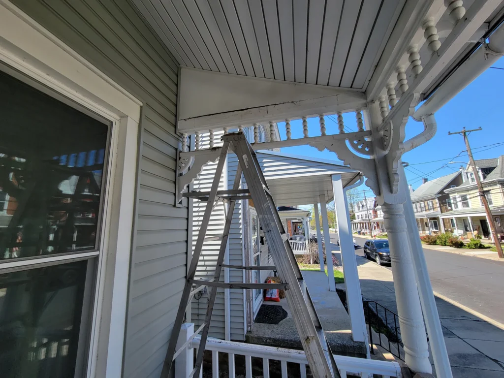 A ladder on a porch with wood joists