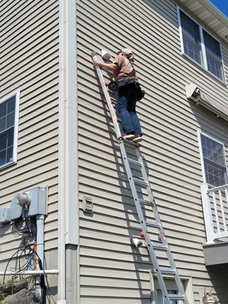 Dan on a ladder installing a vent cap